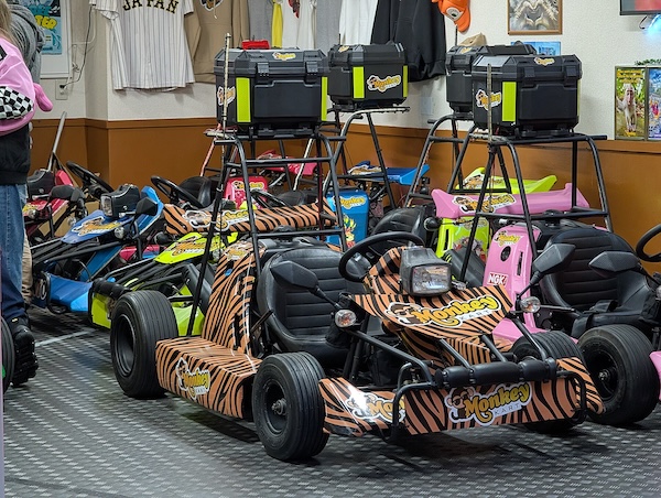 A fleet of colorful street-legal go-karts parked inside a Shibuya garage